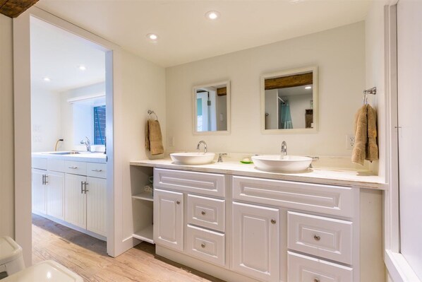 A modern bathroom with two sinks, white cabinetry, and a large mirror. - Sunshine Coast Beach-Front Cottage in Stunning Roberts Creek (Roberts Creek)