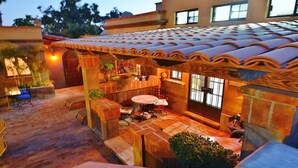 Un espacio al aire libre con techo de baldosas, asientos exteriores y una pequeña mesa.