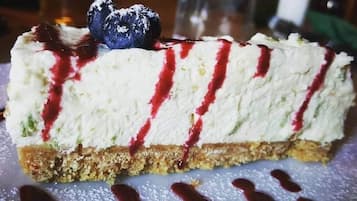 A slice of cheesecake with a berry compote and a blueberry on top.