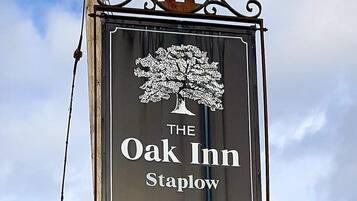Une enseigne pour l’auberge The Oak Inn, située à Staplow, avec un emblème représentant un arbre.