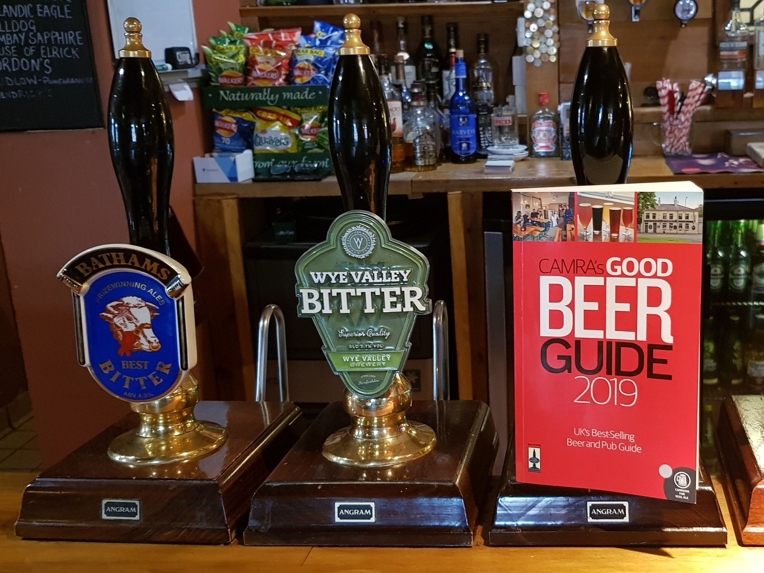 A bar with three beer taps labeled 'Bathams Best Bitter', 'Wye Valley Bitter', and 'Camra's Good Beer Guide 2019'.