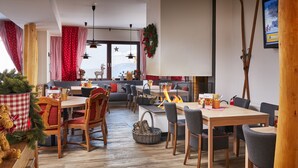Un rincón comedor acogedor con muebles de madera, chimenea y decoraciones festivas.