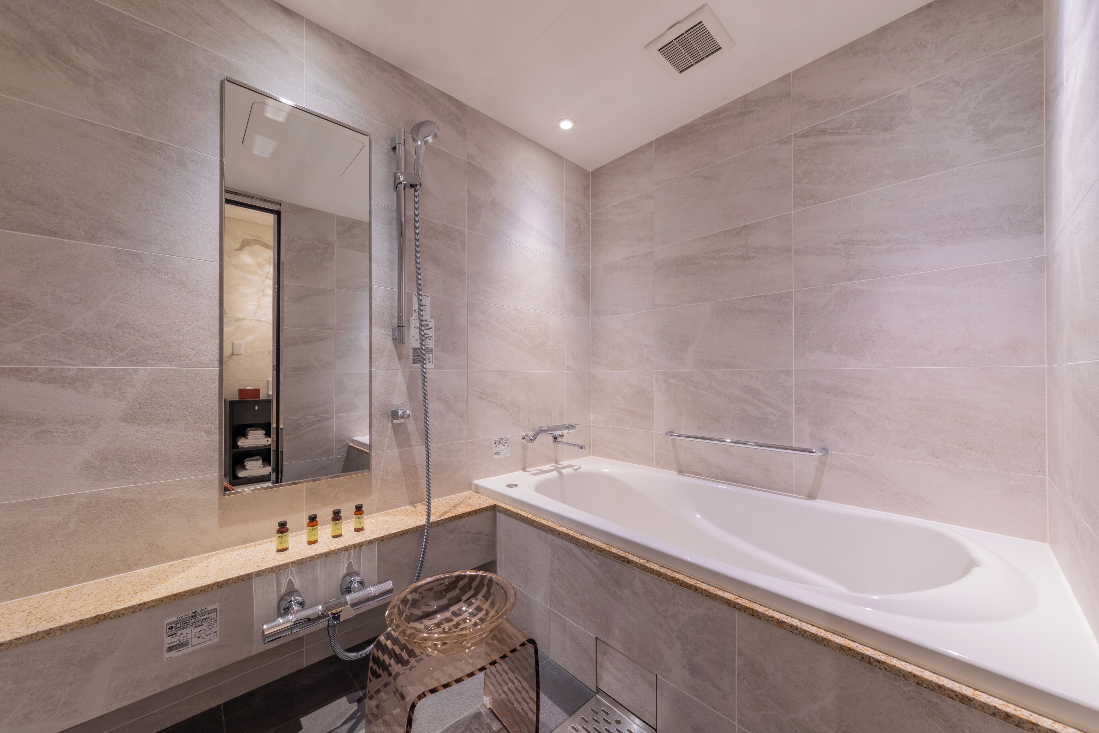 A modern bathroom with a large bathtub, a shower, and a vanity with a mirror.