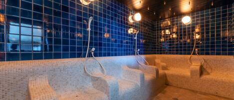 A spa area with mosaic-tiled walls and benches.