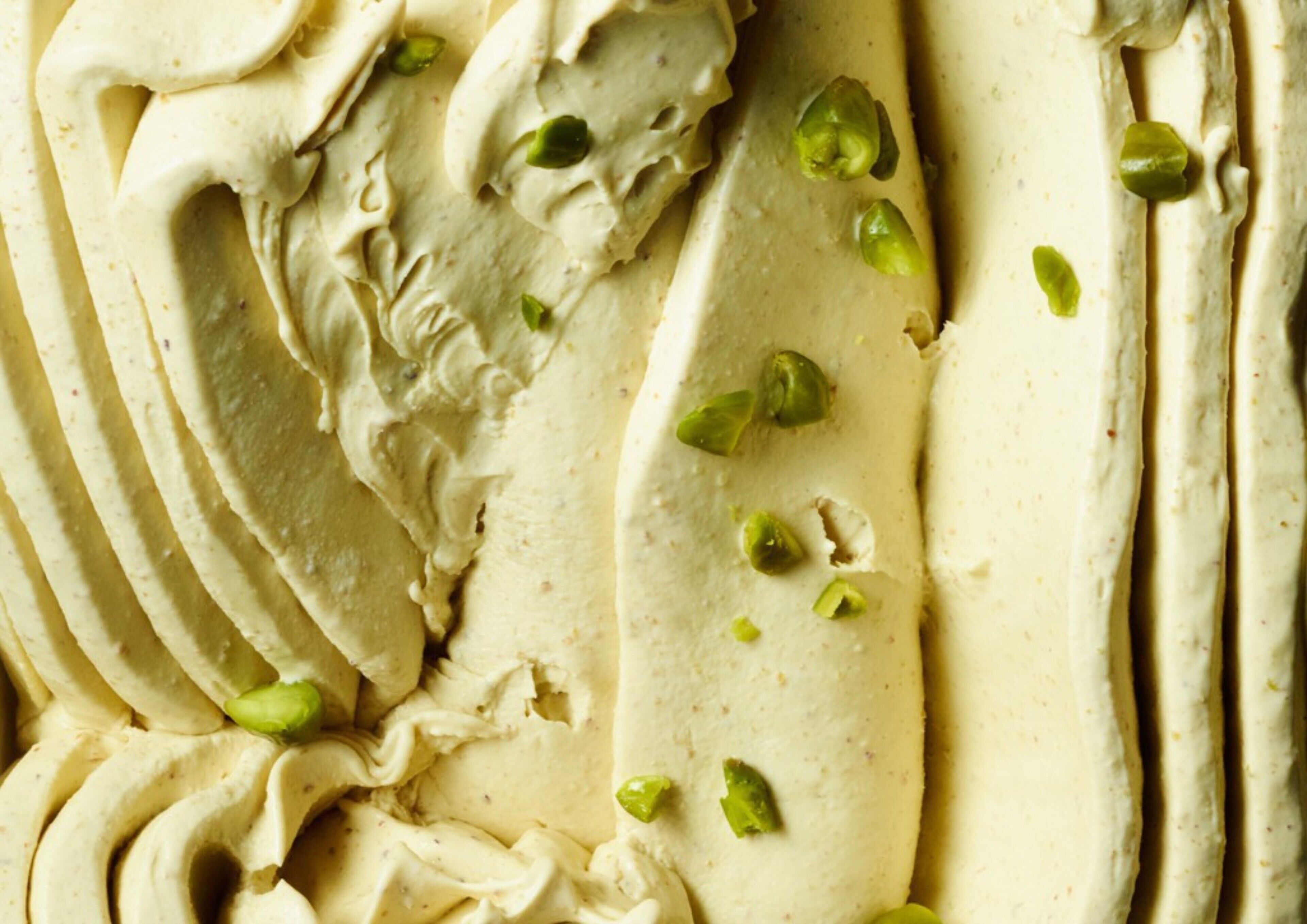 A close-up of a creamy dessert with pistachio garnish.