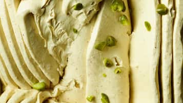 Et nærbillede af en cremet dessert med pistaciepynt.
