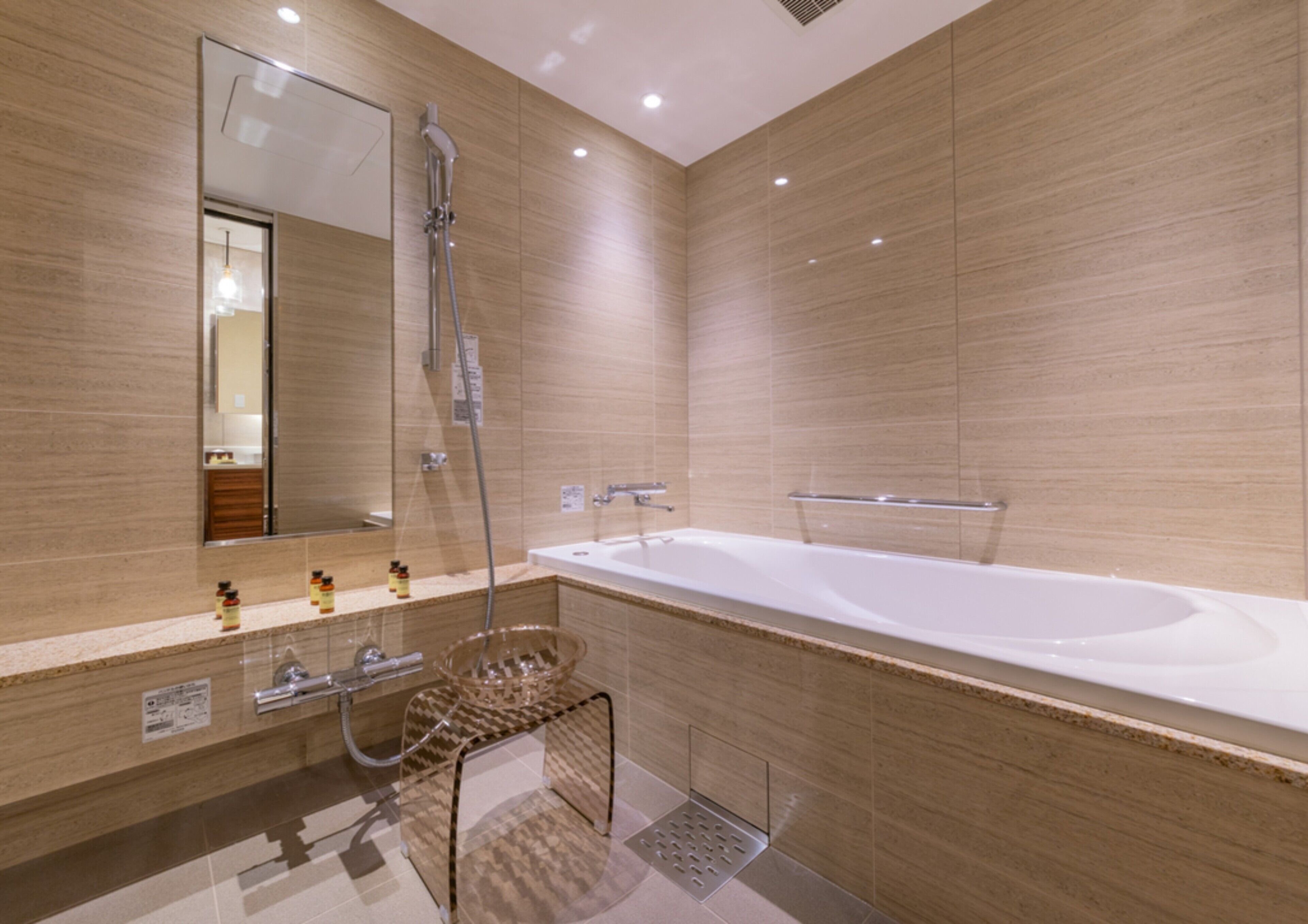 A modern bathroom with a large bathtub, a shower, and a vanity with a mirror.