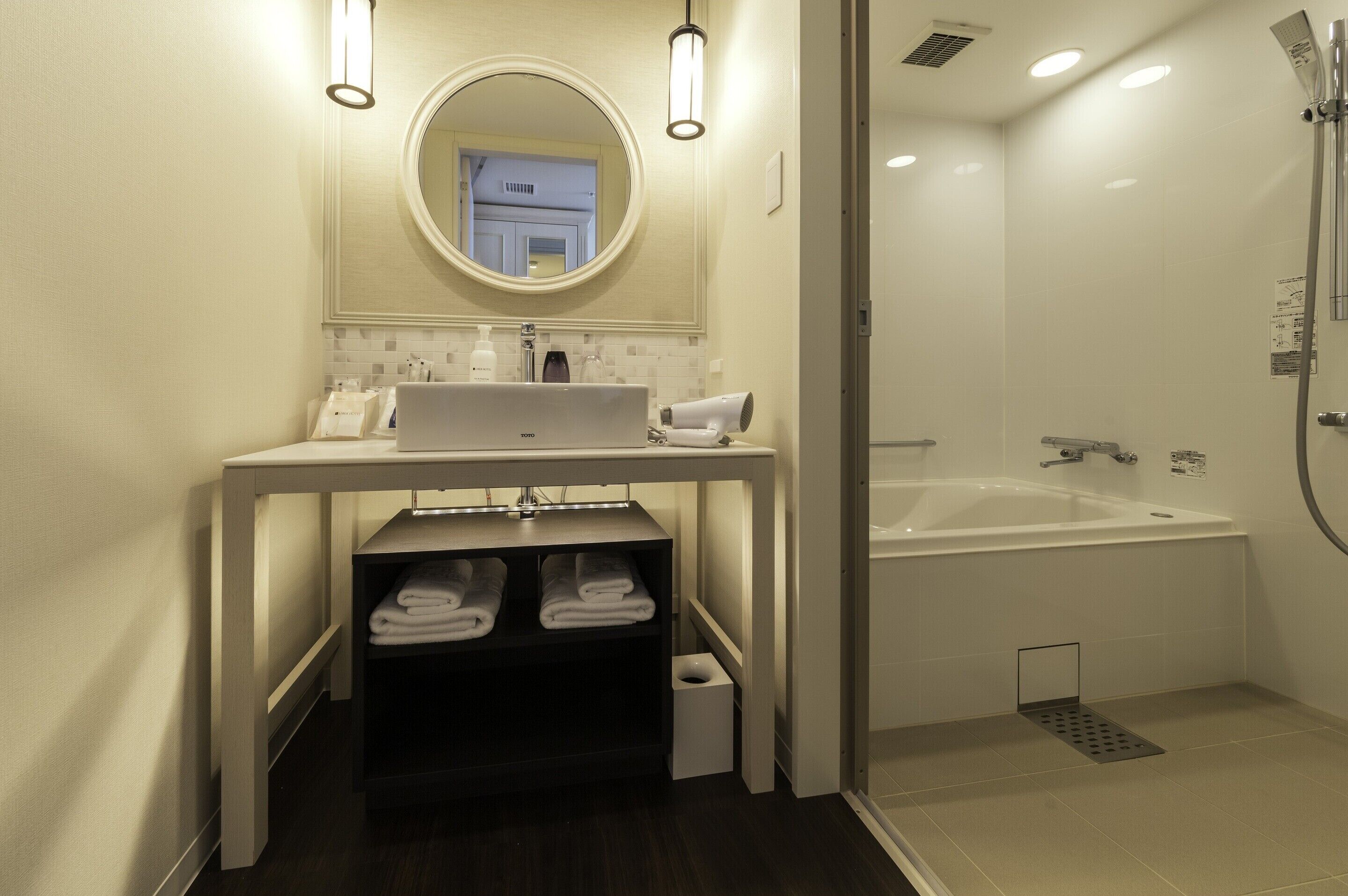 Une salle de bain moderne avec un lavabo, un miroir et une douche.