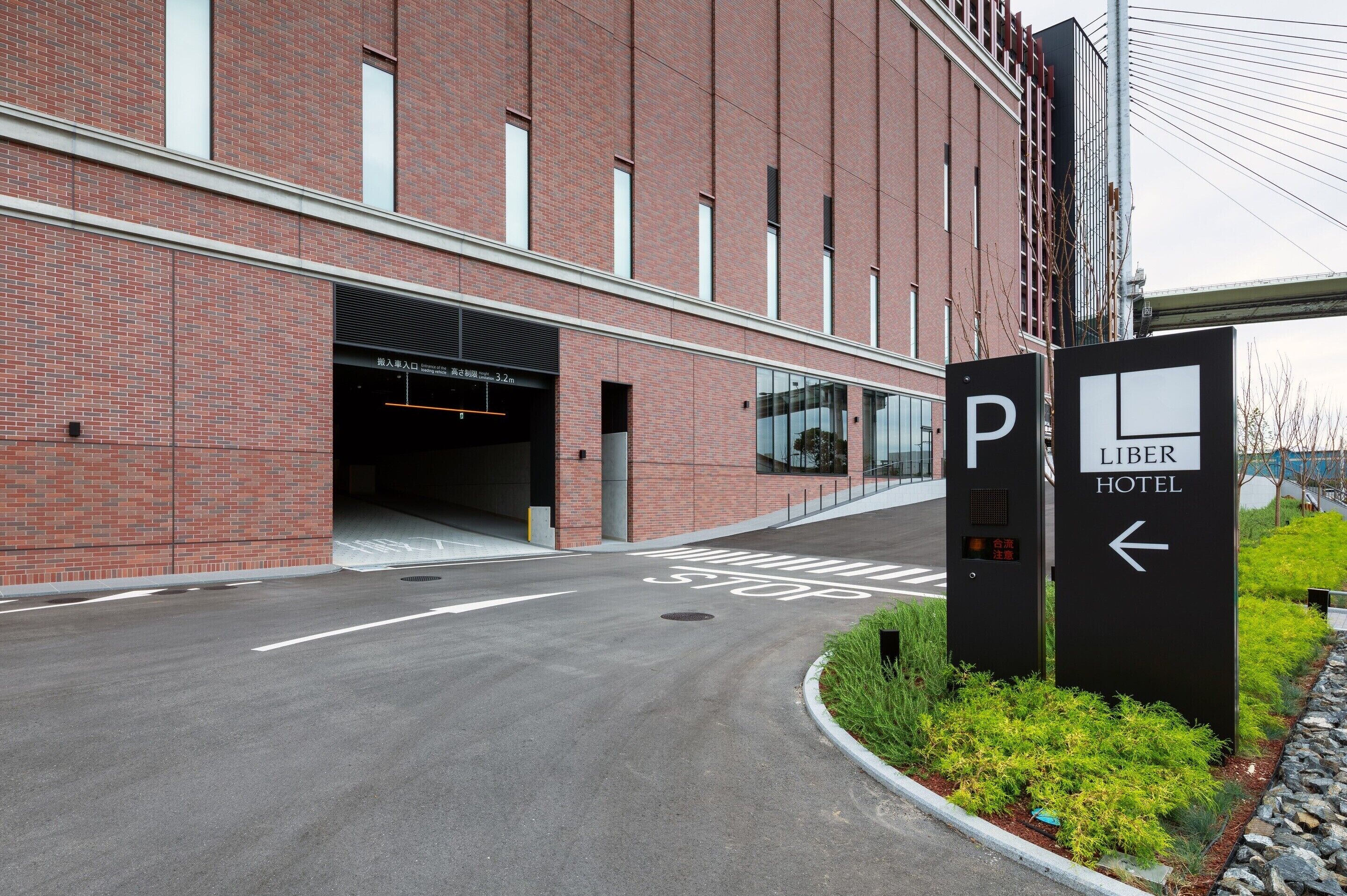 A hotel entrance with a parking sign and a pedestrian crossing.