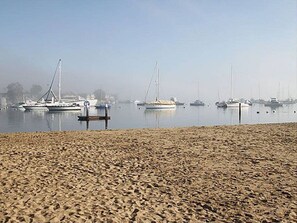 Une plage où des bateaux sont amarrés dans une eau calme.