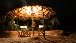 Un parasol de plage avec une table et des chaises en dessous.