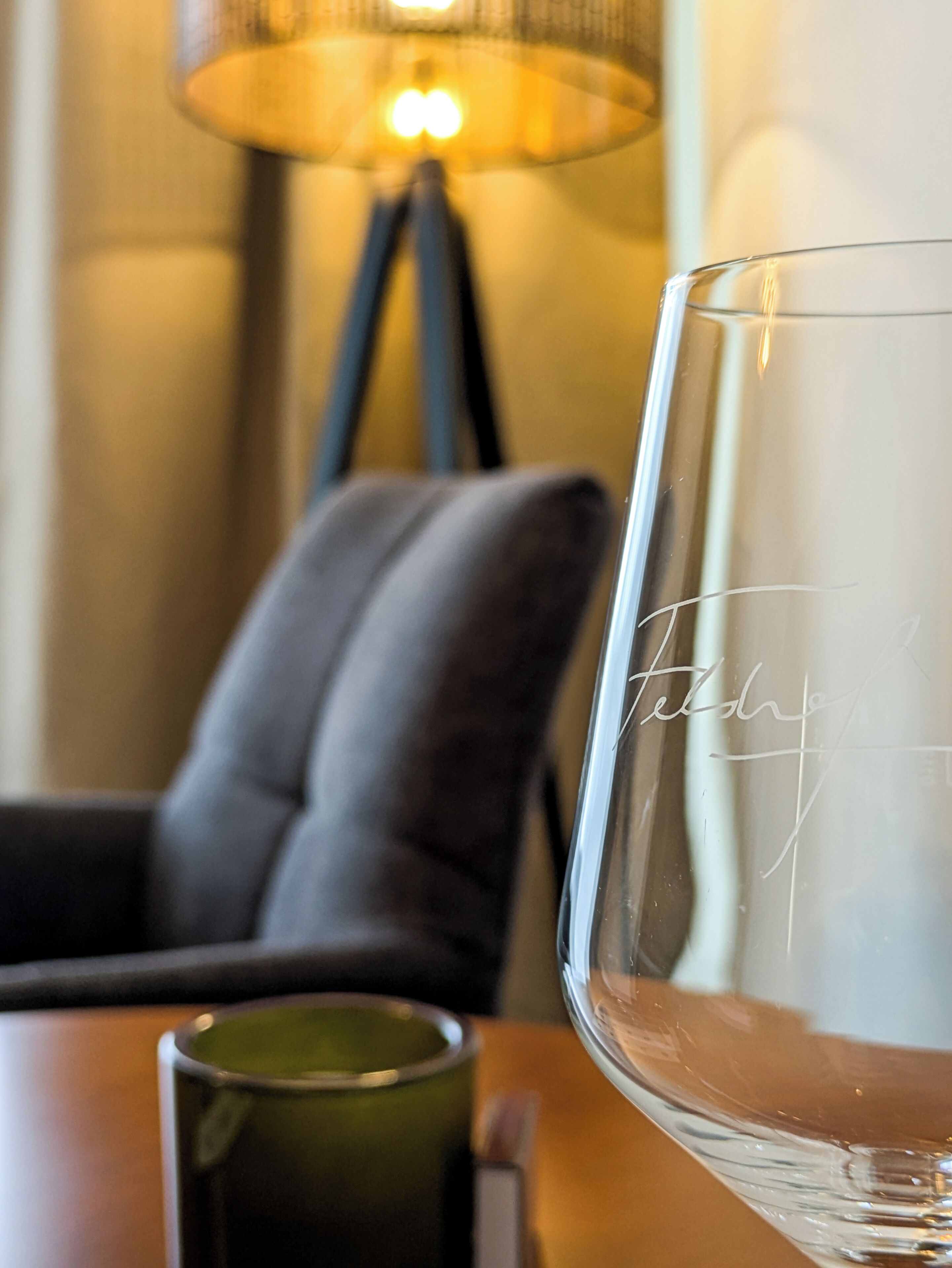 Een glas, een lamp en een stoel in een kamer.