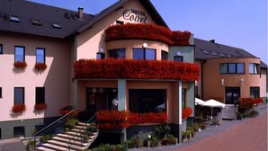 Un hotel con una entrada destacada, una escalera que conduce a la entrada y un letrero sobre la entrada que dice "Hotel Court".