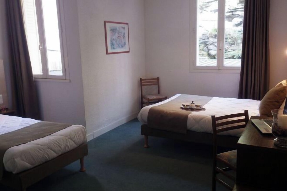 Una habitación de hotel con dos camas, un escritorio y una silla.