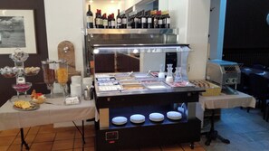 Una mesa de buffet con diversos alimentos y una selección de vinos.