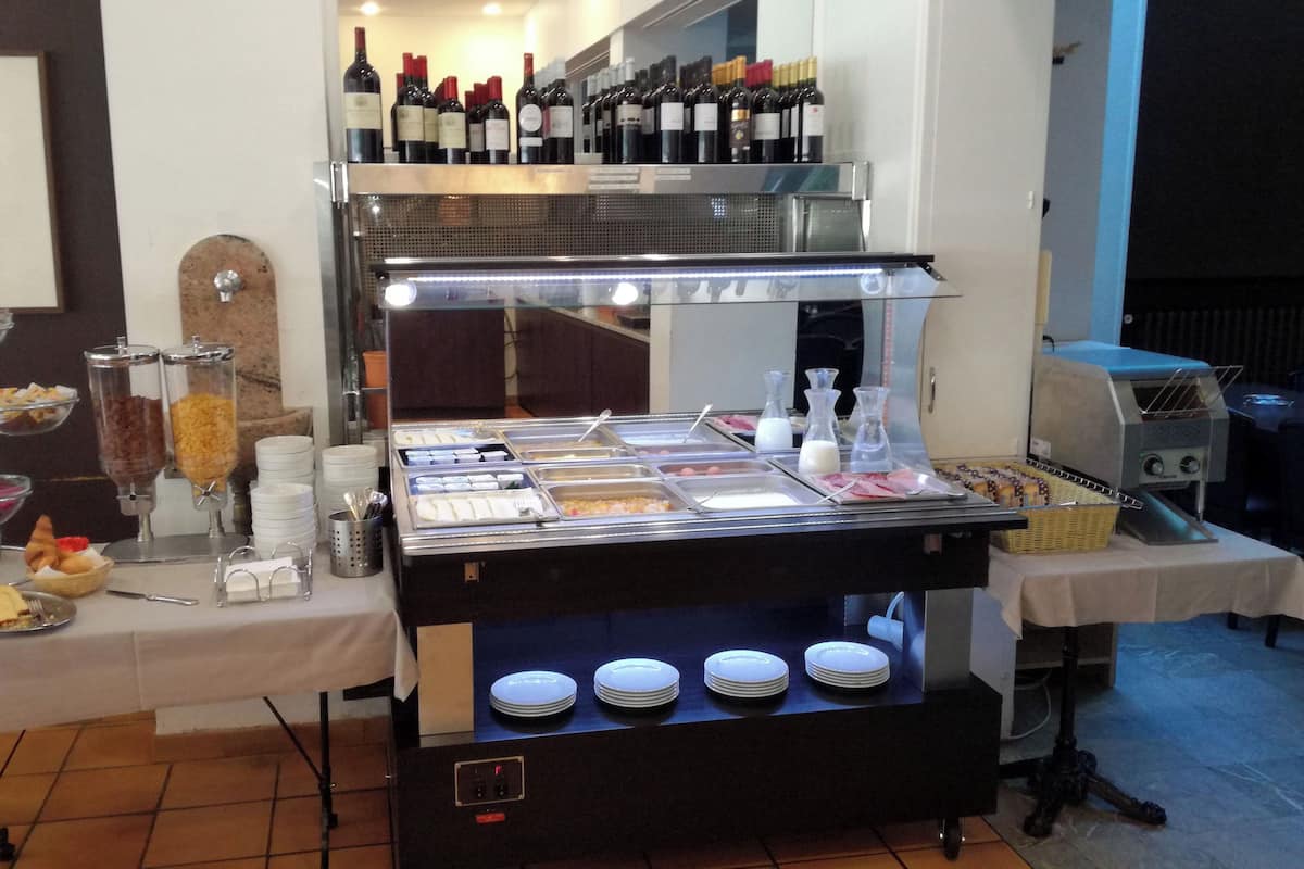 A buffet setup with various food items and a wine selection.