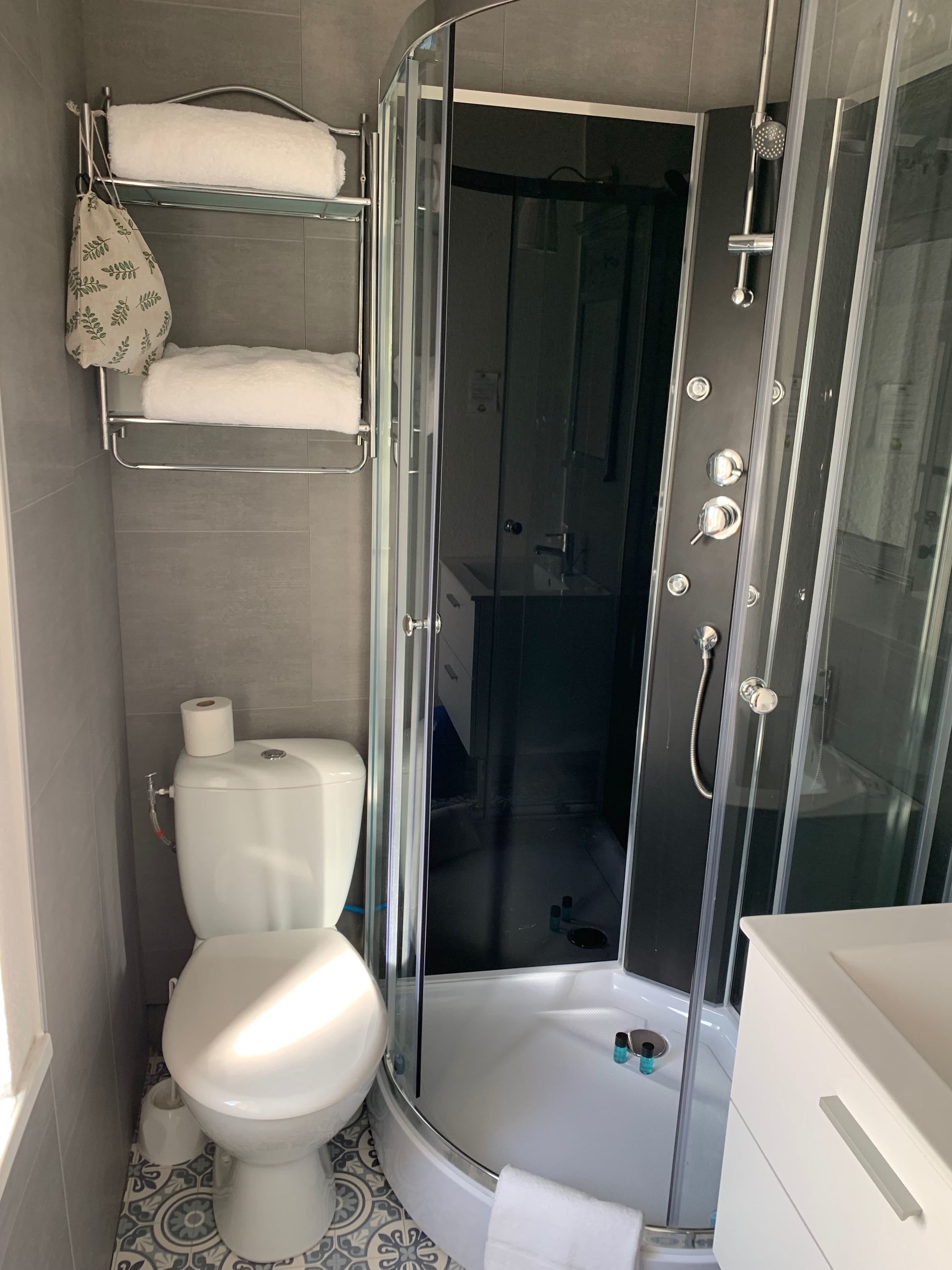 Un baño moderno con ducha de vidrio, inodoro y lavamanos.