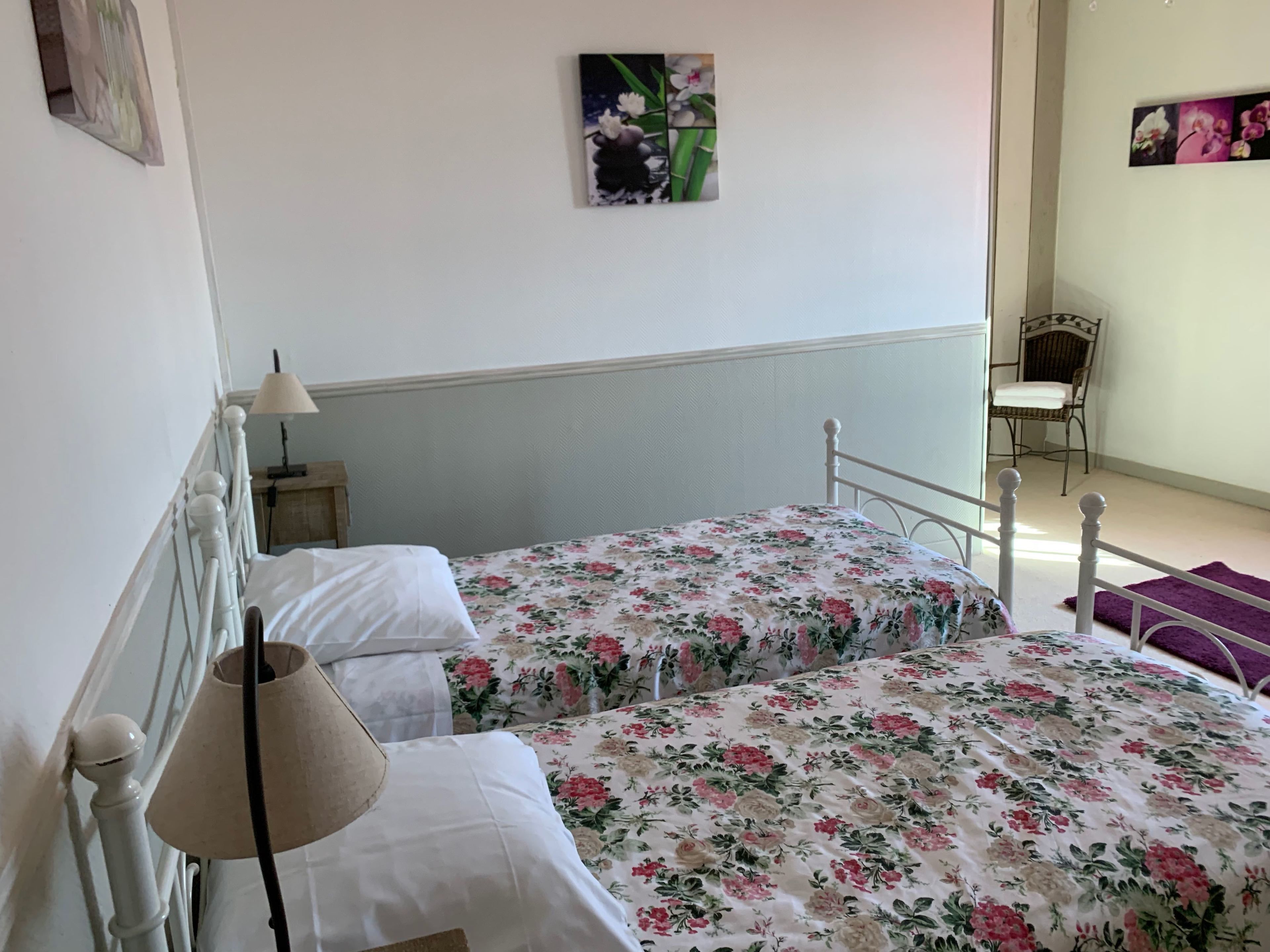 Quarto com cama, mesa de cabeceira, luminária e cadeira.