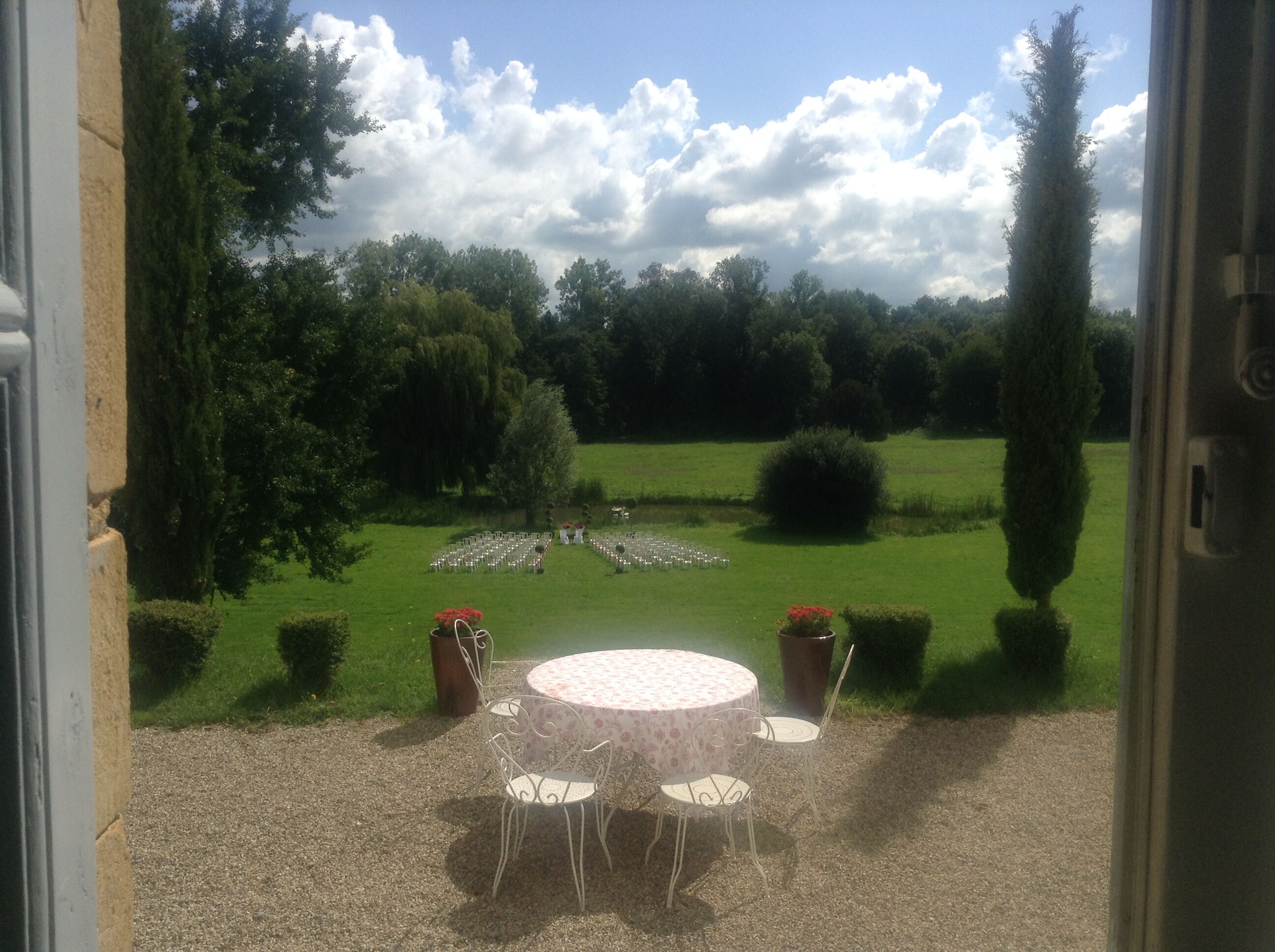 A patio with a round table and chairs, surrounded by a gravel path.