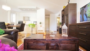 A modern living room with a wooden coffee table, a sofa, and a TV on the wall. - Apartment Marieta (Split)