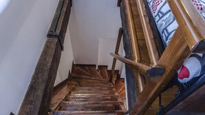 A wooden staircase with a handrail and a plush toy on the right. - Maurizio House (Venice)
