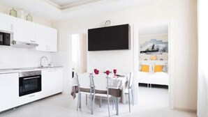 A modern kitchen with white cabinets, a built-in oven, and a dining area with a white table and chairs. - 5 Tourist House Apartment Centre Bologna (Bologna)