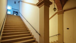 A staircase with beige steps and a handrail, leading to a door with a round light fixture above it. - 5 Tourist House Apartment Centre Bologna (Bologna)