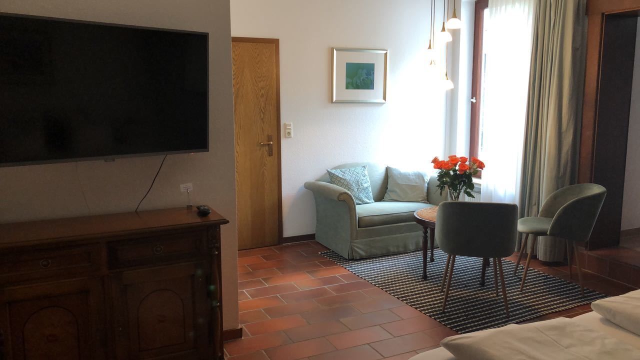 A living room with a television, a sofa, a coffee table, and a chair.