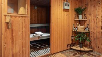 Ein Holz-Saunaraum mit einer Sitzbank, Handtüchern, einer Uhr, einer Steuerung und Regalen mit Pflanzen und Flaschen.