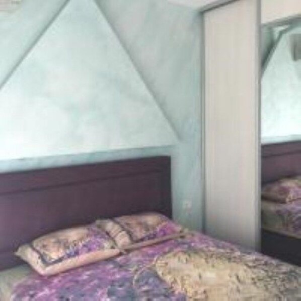 A bedroom with a bed, a headboard, and a mirror. - Apartment Seaview 23 (Budva)