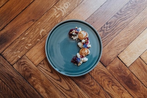 A round ceramic plate with food items on a wooden floor. - Angermühle Landgasthof (Altenmarkt an der Alz)