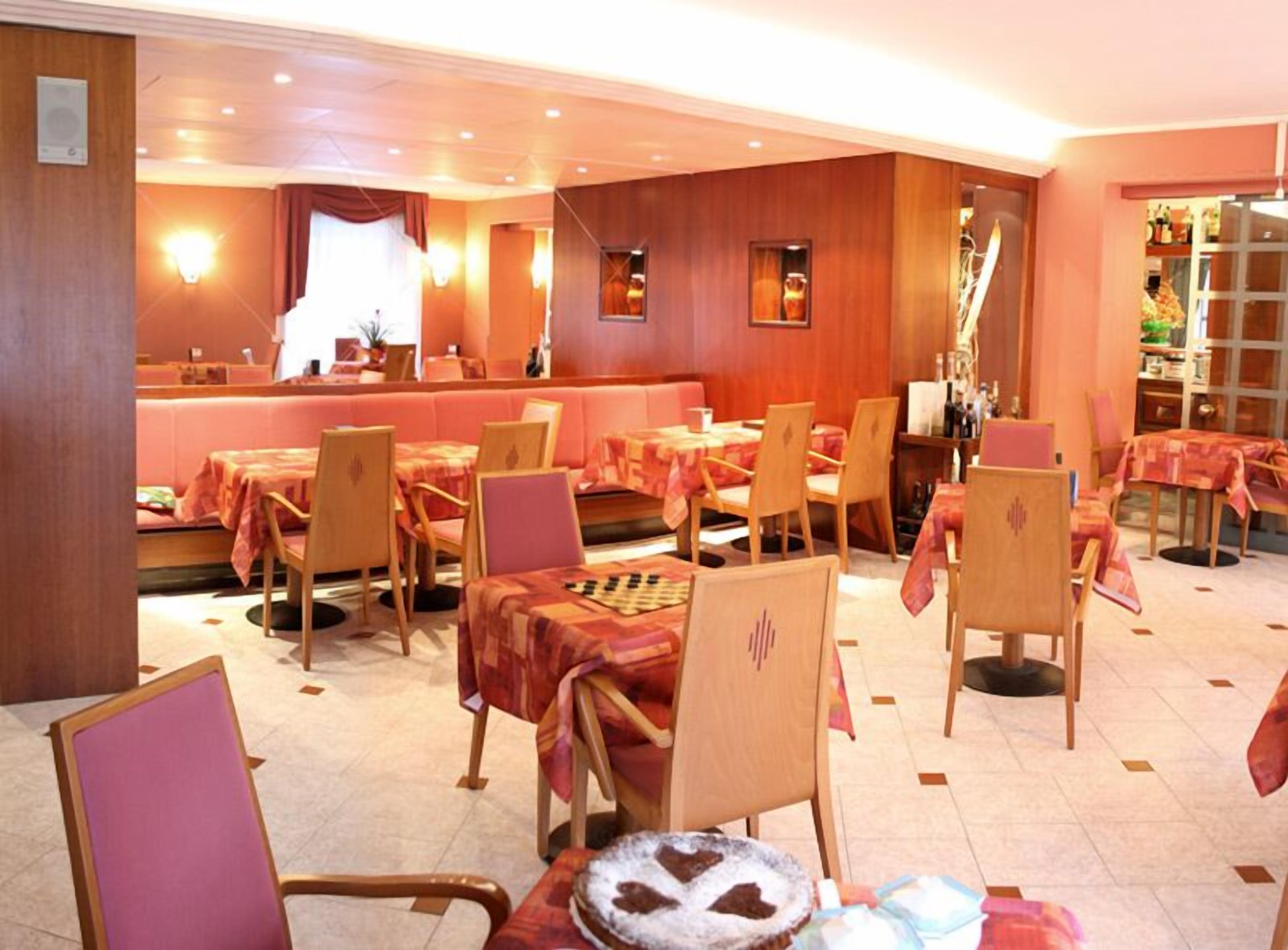 Ein Restaurant mit mehreren Tischen und Stühlen, einer Bar und einer Theke.