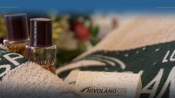 Ein Handtuch mit dem Aufdruck 'NIVOLANO SPA' und eine Flasche 'NIVOLANO'-Produkt.