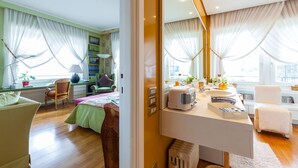 A modern bedroom with a large bed, bedside tables, a desk, and a chair. There are curtains, a window, and a mirror. - O House Posillipo by Napoliapartments (Naples)