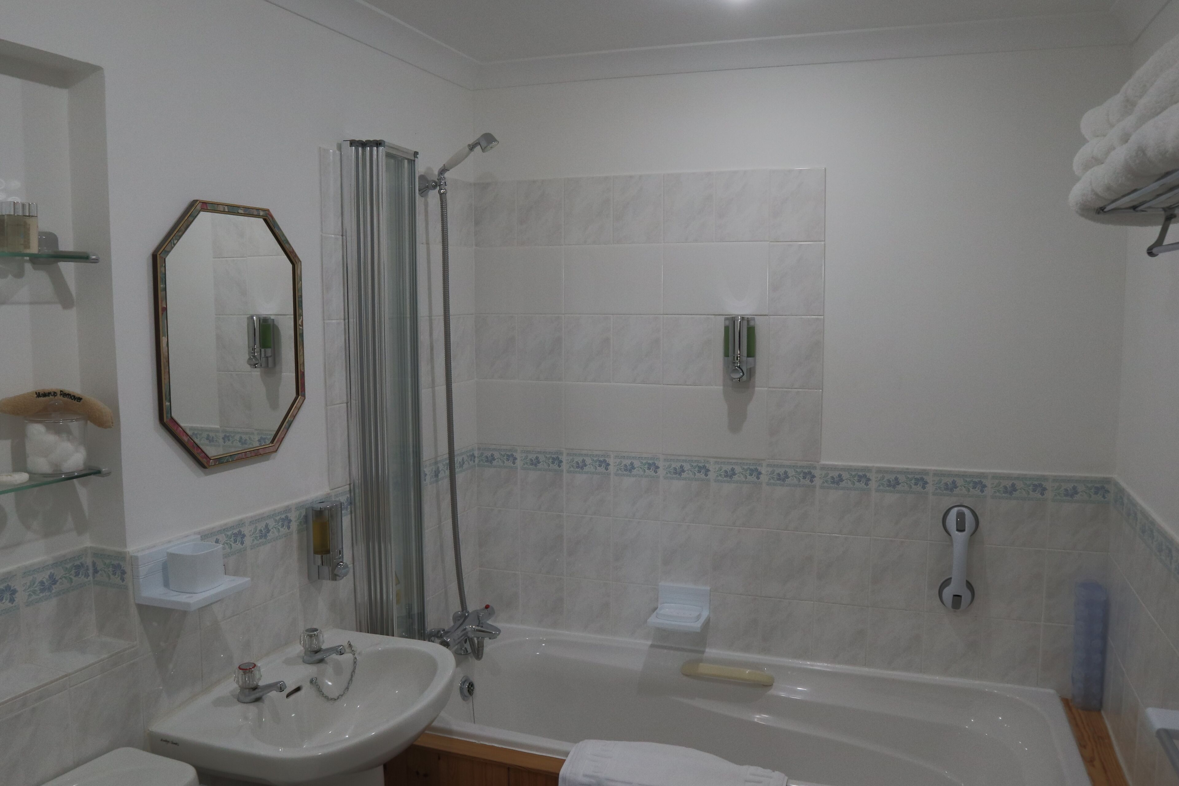 A bathroom with a bathtub, a sink, a toilet, a shower, and a mirror.
