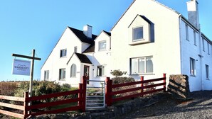 En hvid bygning med en rød port og et skilt, der viser 