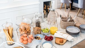 Un buffet della colazione con diversi cibi, tra cui pane, uova, frutta e bevande.