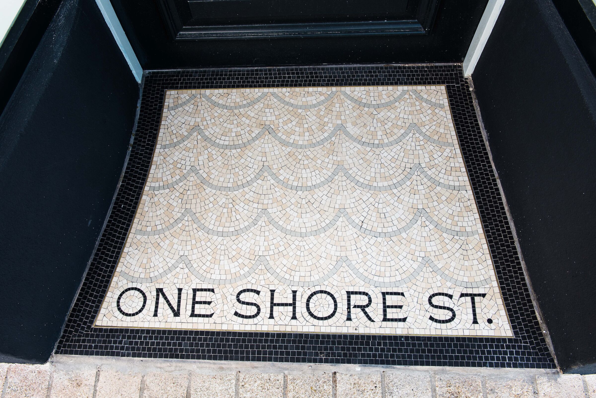 A tiled entrance with the inscription "ONE SHORE ST."