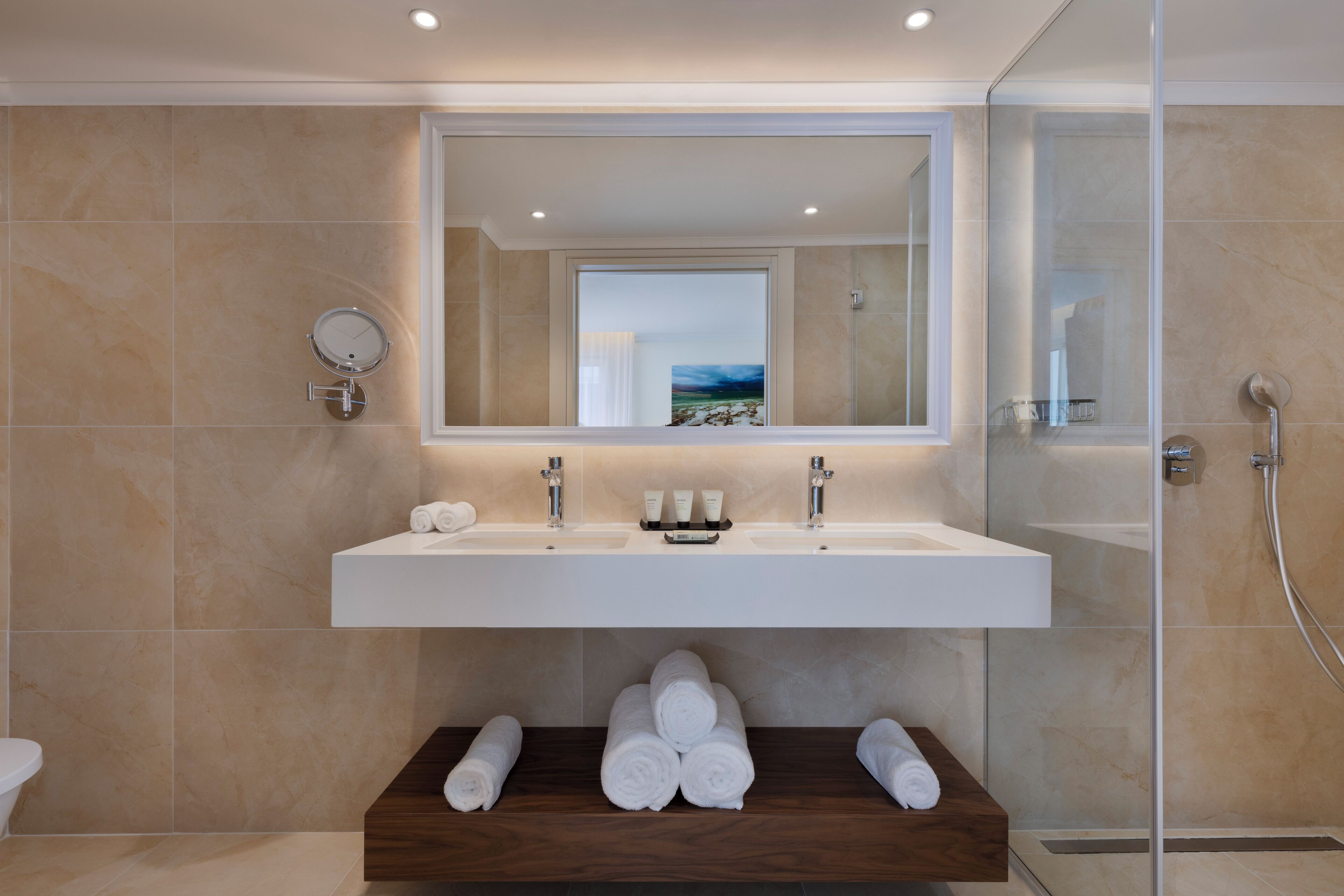 Un baño moderno con un espejo grande, dos lavabos y una zona de ducha.