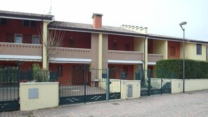 Un immeuble résidentiel à plusieurs étages, doté d’une façade en briques, de balcons et d’une entrée sécurisée par un portail.