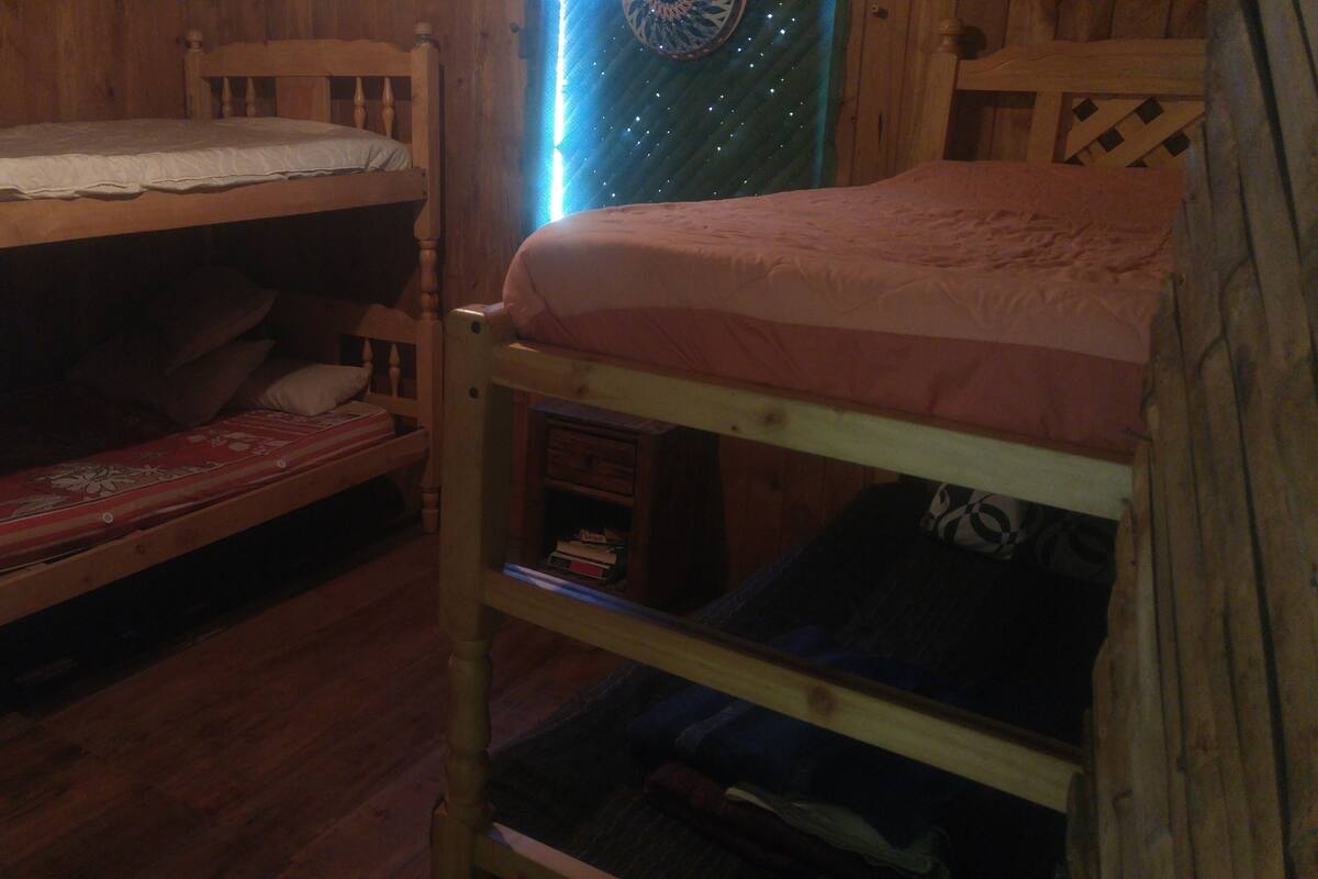 Habitación con literas de madera, una inferior y otra superior.