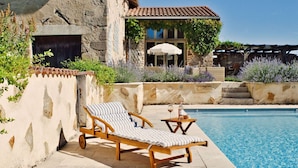 A pool area with two sun loungers and a stone wall. - Les Picardies (Lesterps)