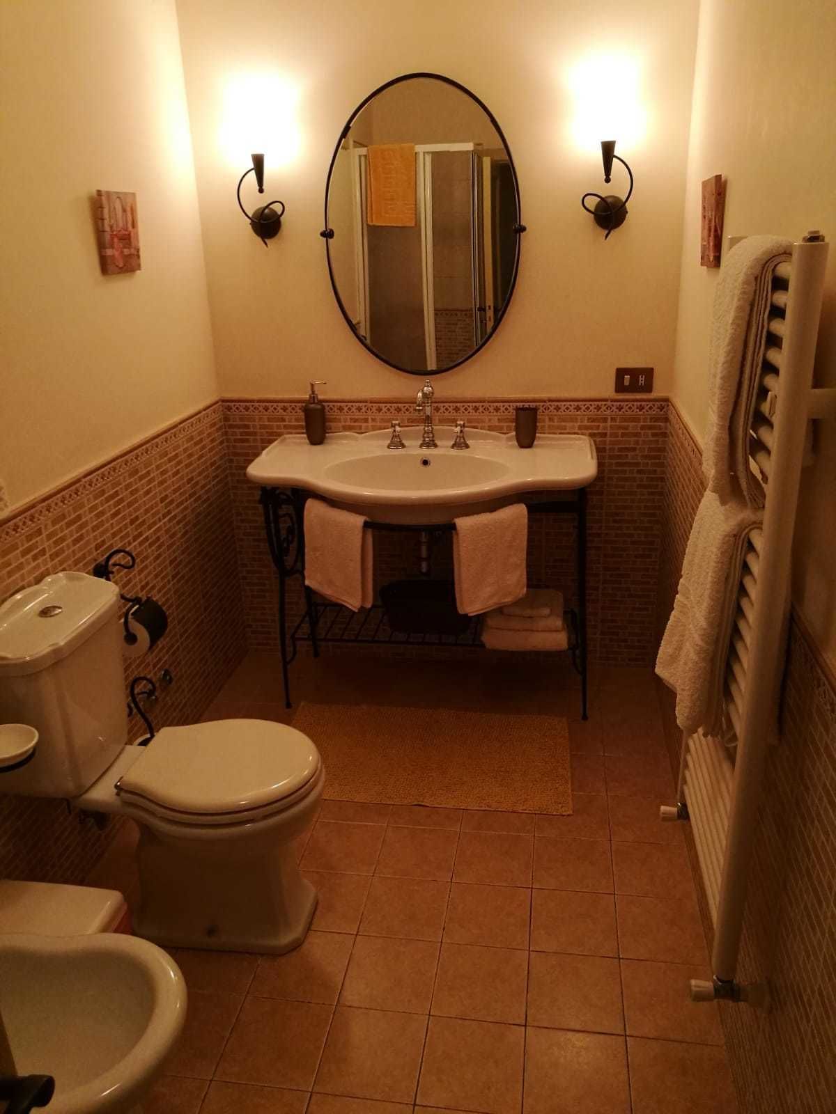 Un baño con inodoro, lavabo, espejo y bidé.