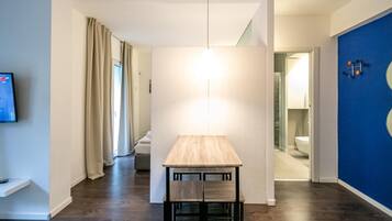 Una stanza moderna con un tavolo di legno, una lampada a sospensione e una parete azzurra.