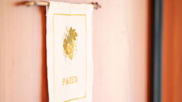Een witte handdoek met een goud geborduurd design en het woord 'PAID' op een houten oppervlak.