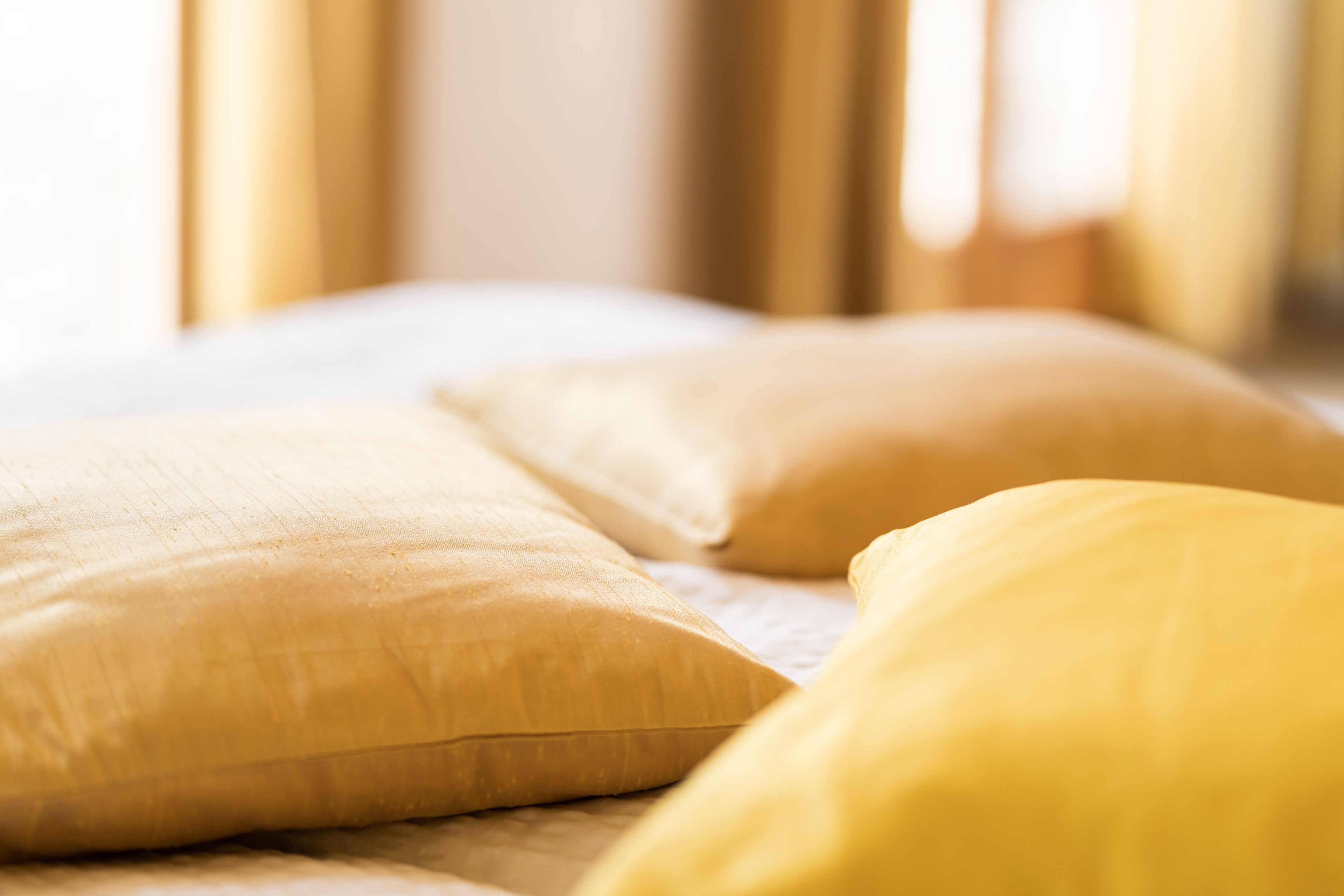 Ein Bett mit Kissen und Decke.