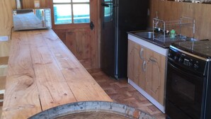 Una cocina con armarios de madera, un refrigerador negro, una estufa y un microondas.