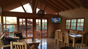 Un interior de madera con zona de comedor, asientos y televisor.