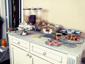 A buffet setup with various food items, including pastries, meats, and condiments. - Maison Landolina (Palermo)
