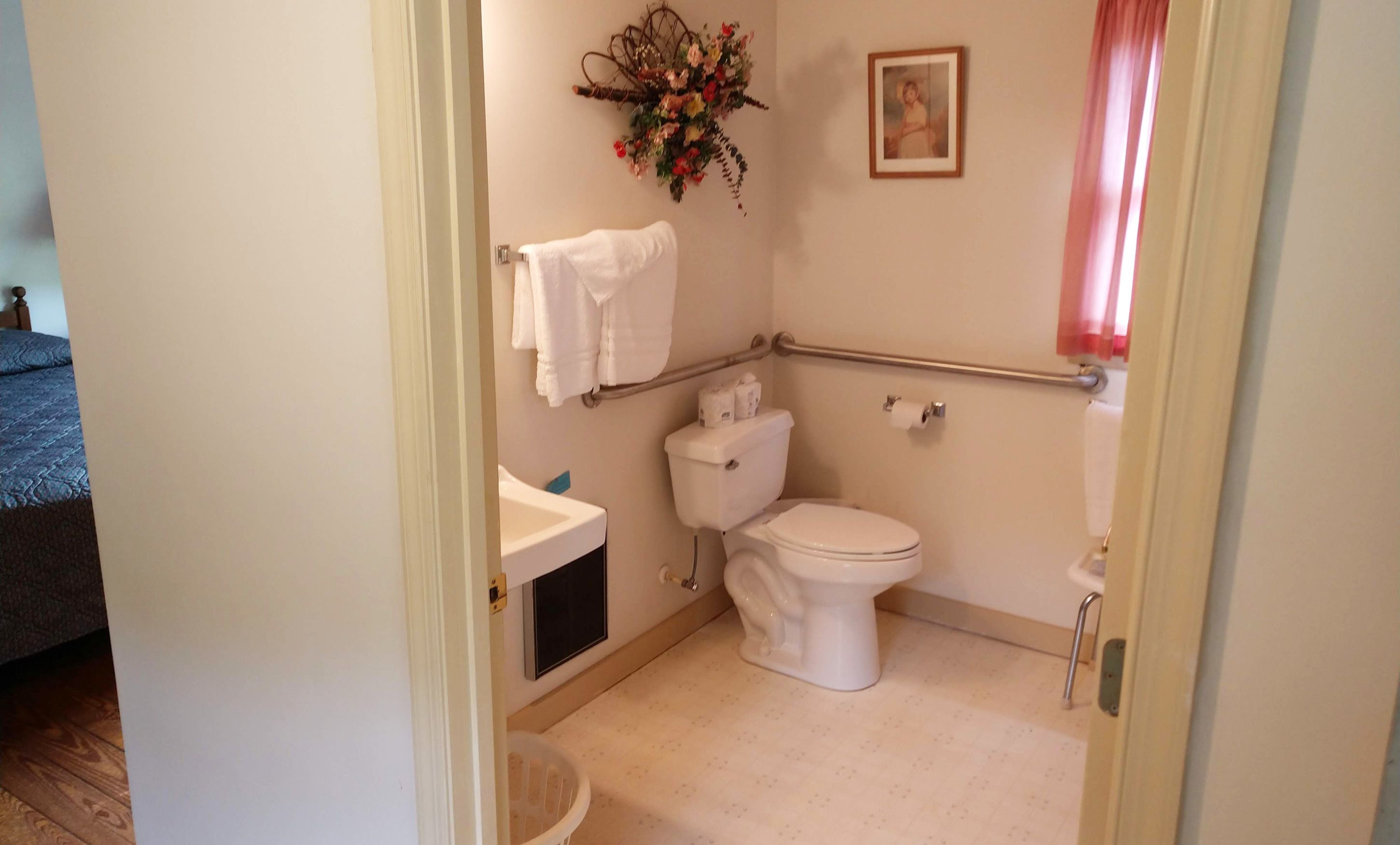 A small, clean bathroom with a toilet, sink, and a shower area.